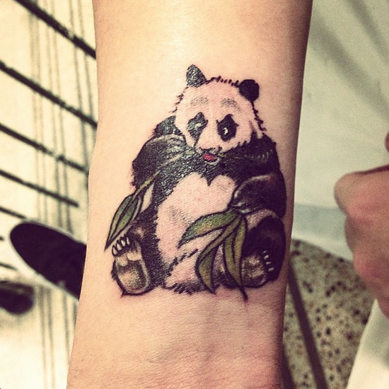 Simply adorable! A cute little panda looks out of this wrist tattoo design  | Ratta Tattoo