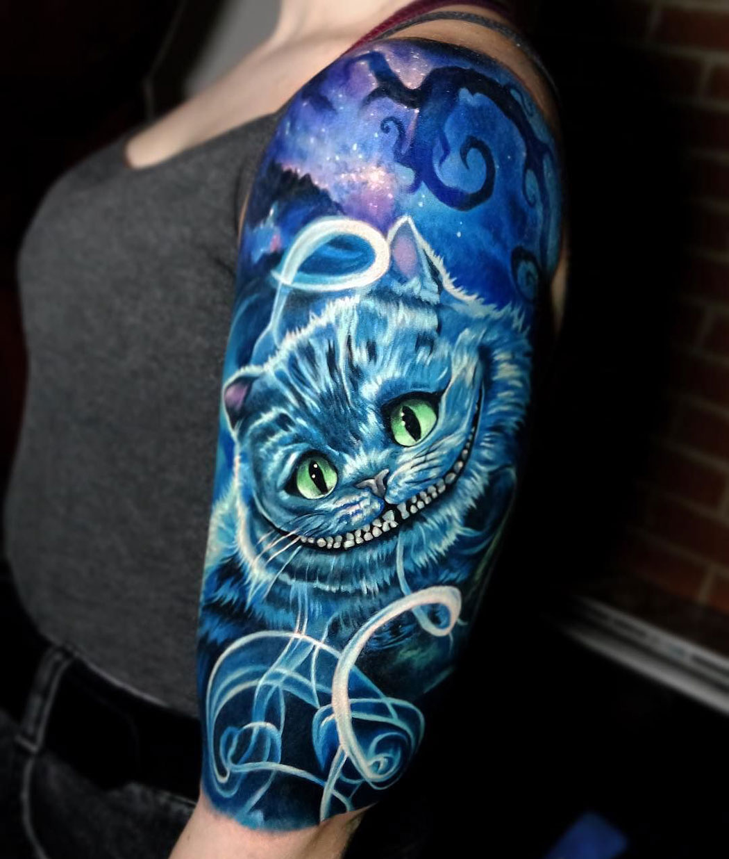 Cheshire cat girl's arm tattoo